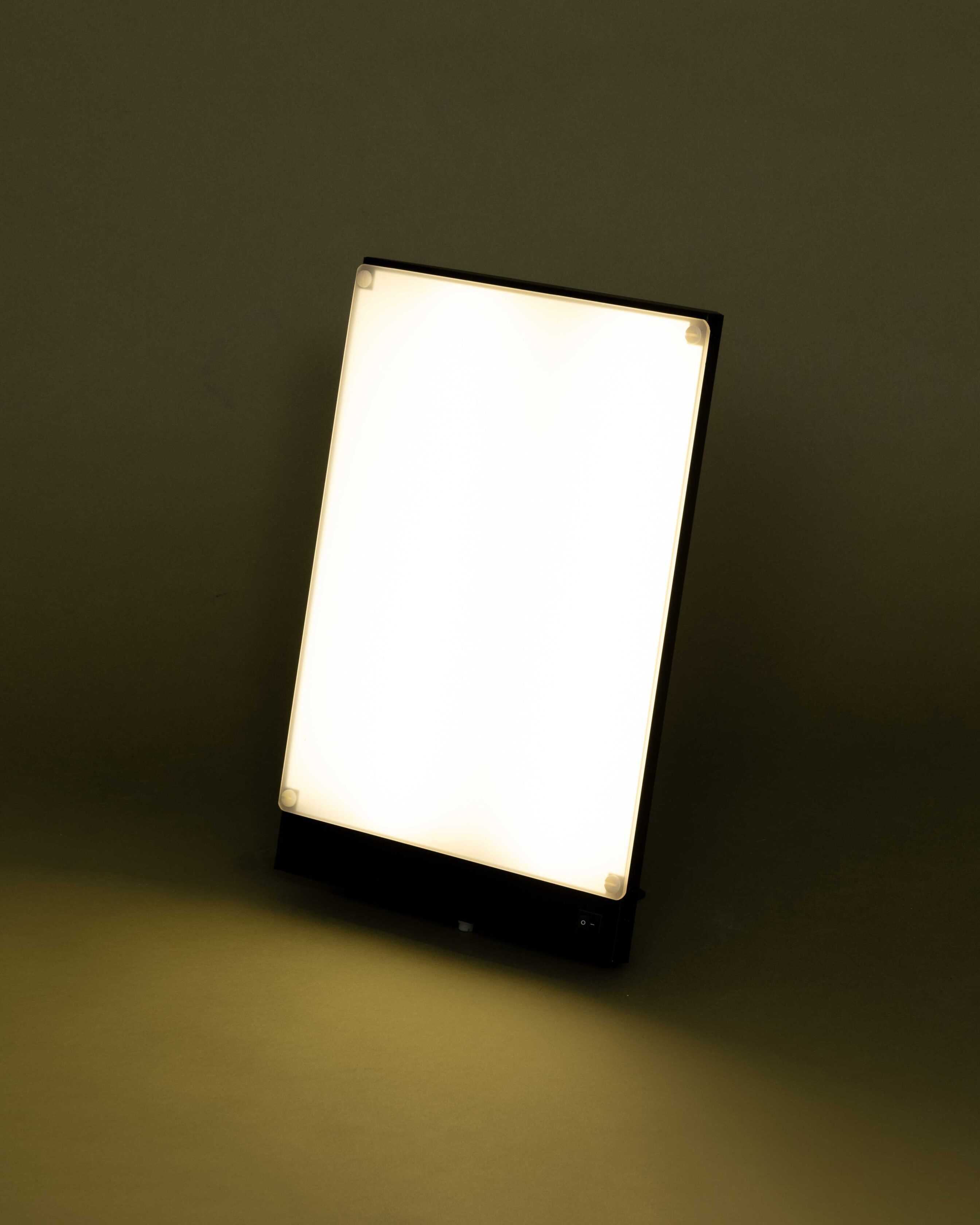 Professional using BOXelite lamp during morning routine at home office desk
